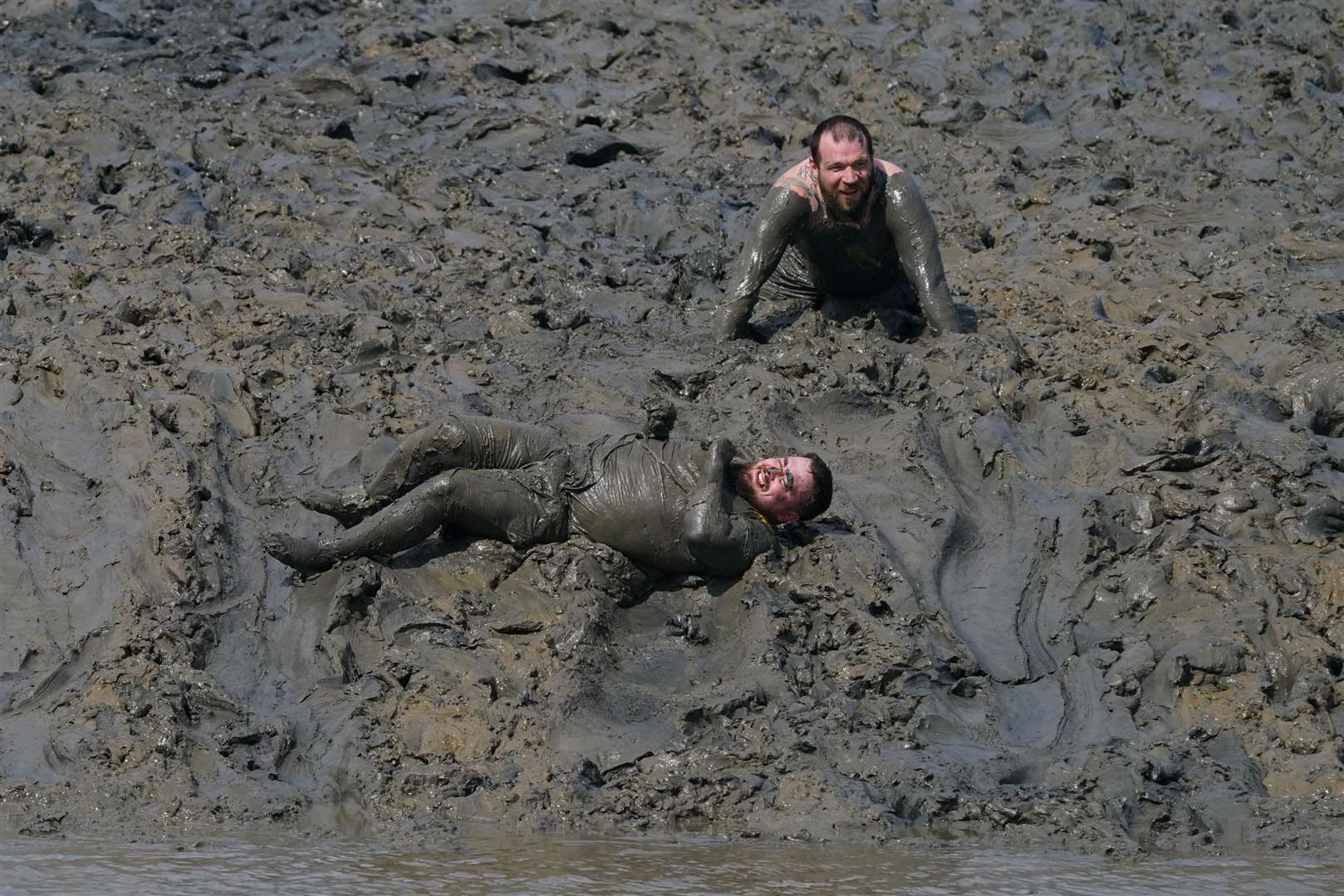 Competitors take part in the annual Maldon Mud Race in Essex (Gareth Fuller/PA)