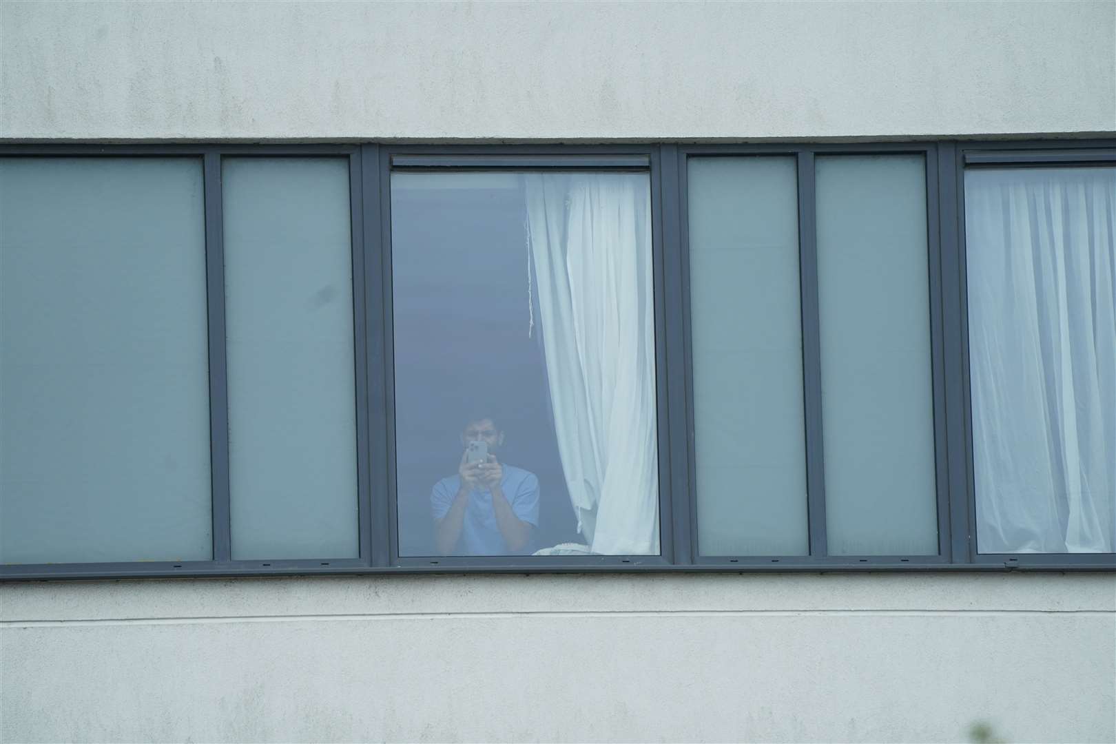 A man at the window of the Holiday Inn Express in Manvers Way, Rotherham, when the rioting was taking place (Danny Lawson/PA)