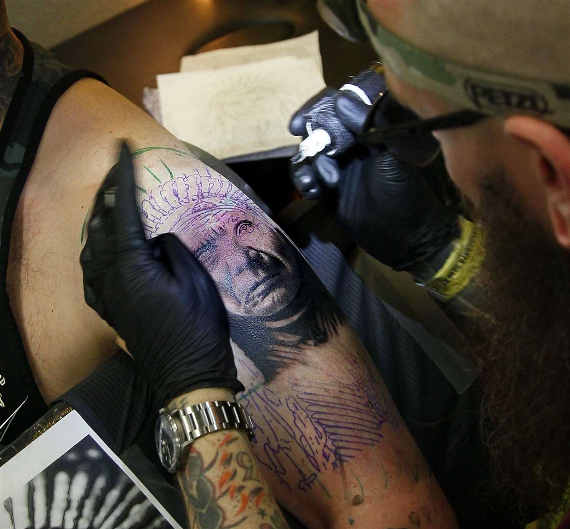 Ben Griffiths from Black River Tattoo, Rainham, working on a design at the convention in 2019. Picture: Sean Aidan