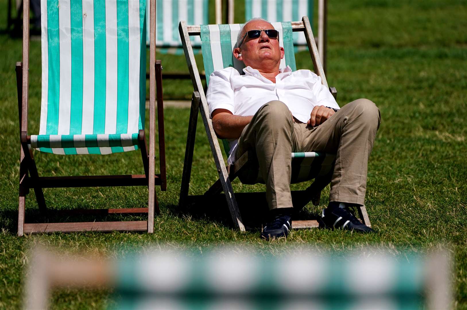 A sunbather lounges on a deck chair in Green Park, London (Jonathan Brady/PA)