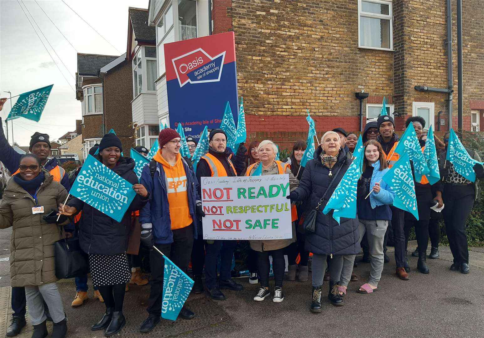 Teachers waving banners and placards on the picket line outside Oasis Academy