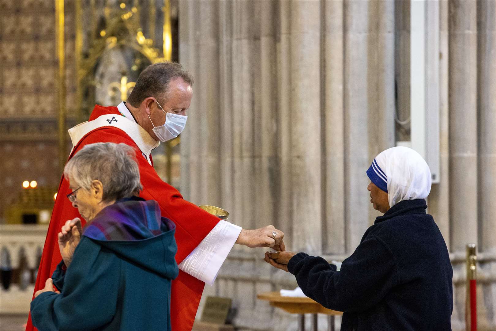 Archbishop Eamon Martin wore a face covering as he distributed communion bread (Liam McBurney/PA)