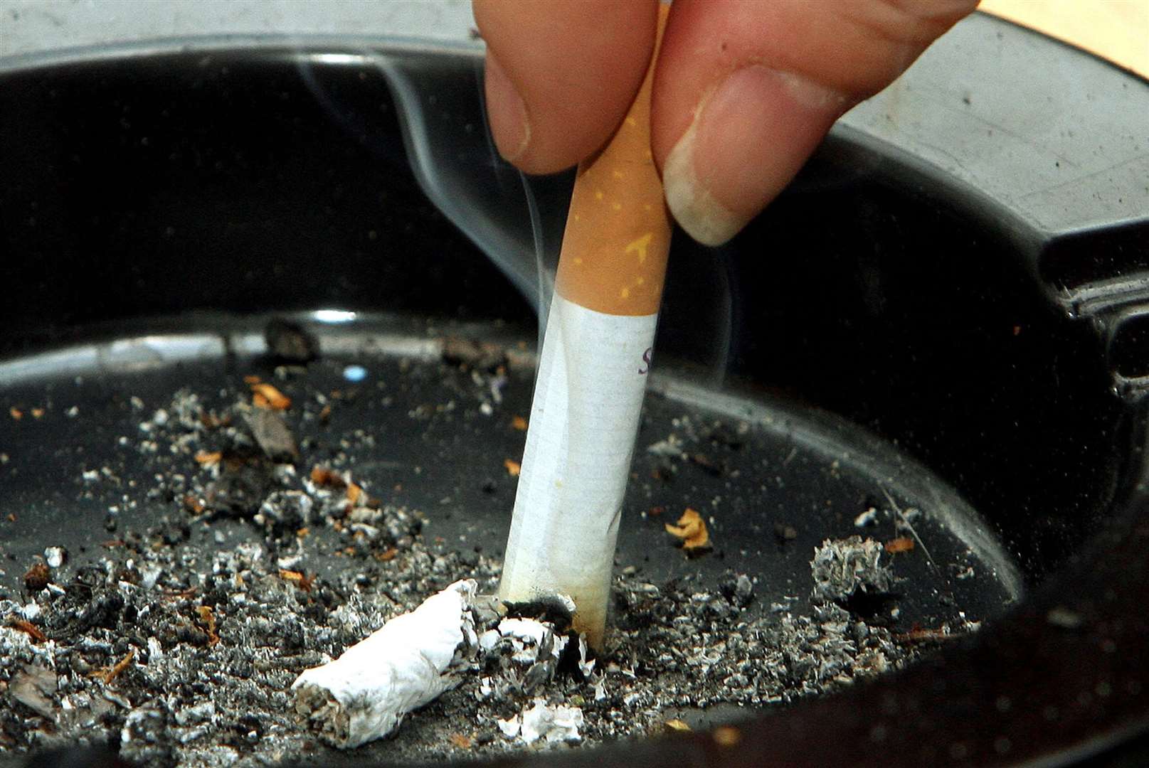 A smoker stubs out a cigarette (Owen Humphreys/PA)