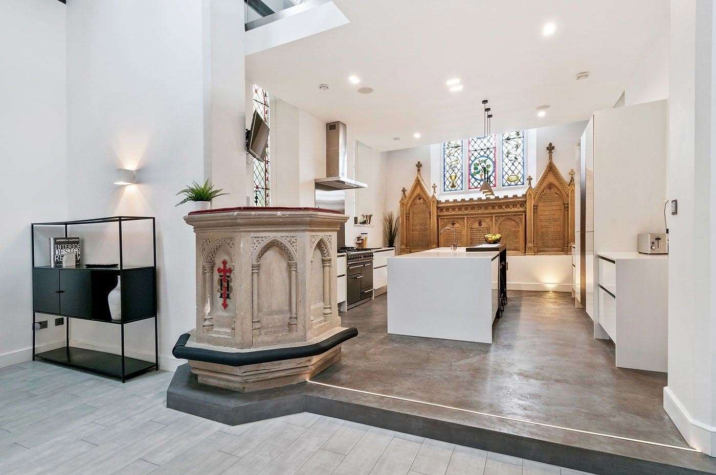 A stone pulpit sits next to a sleek modern kitchen