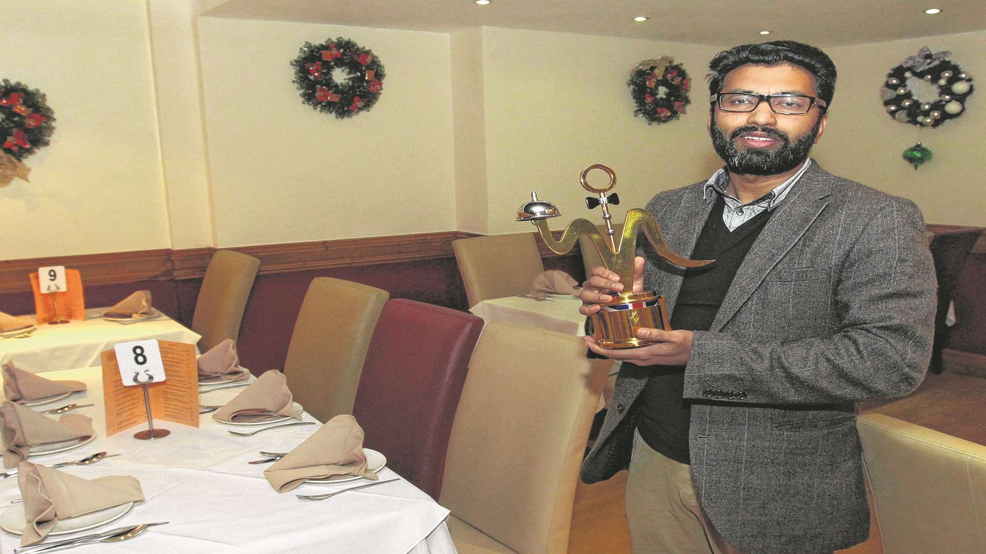 Sham Islam, owner of The Green Spice proudly shows off his British Curry Award for The Best Restaurant in the London