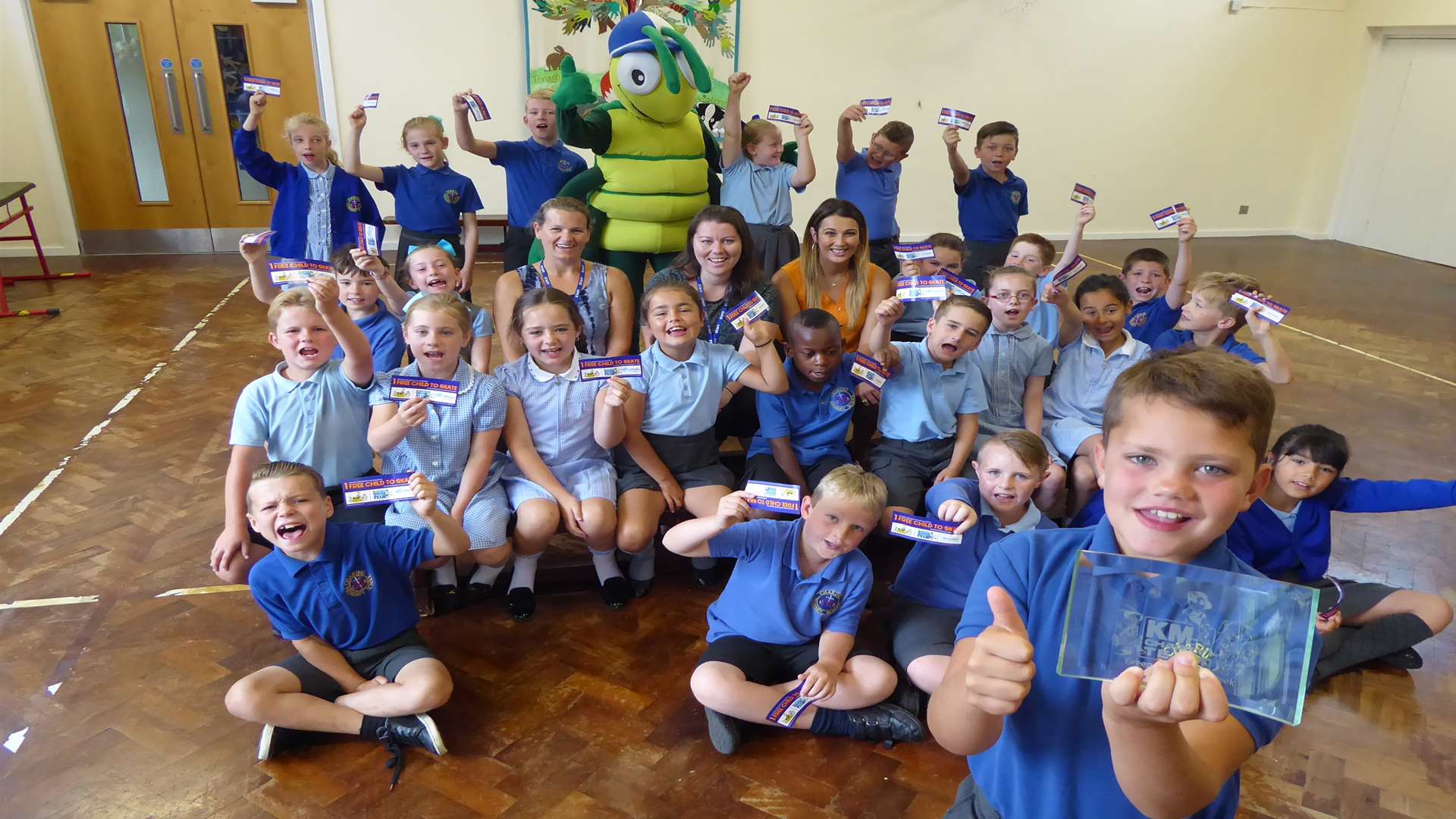 Buster Bug, Leah Macdonald of Three R's Teacher Recruitment and teachers with Levi Hilden and Foxes Class from Charing C of E Primary School with their green class of the week trophy and Silver Blades tickets.