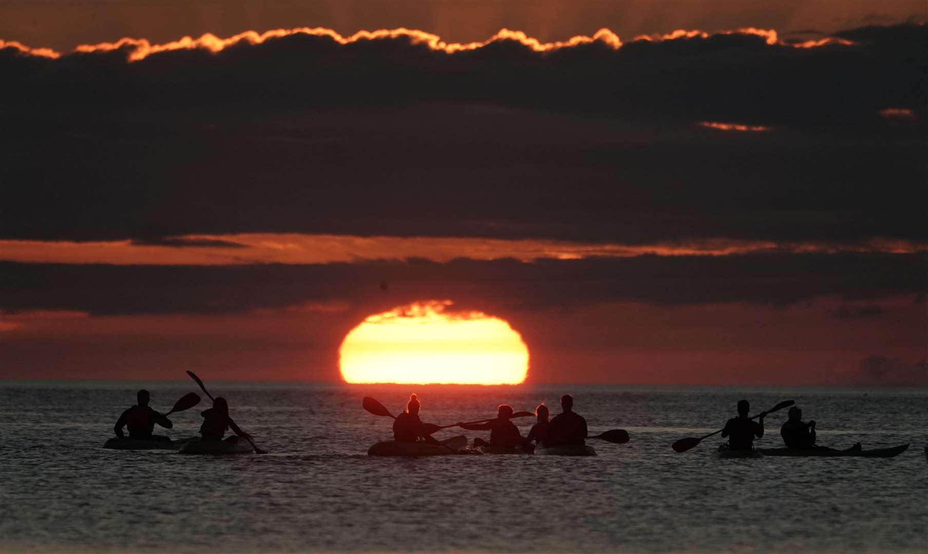 Kayakers watch dawn break in North Tyneside (Owen Humphreys/PA)