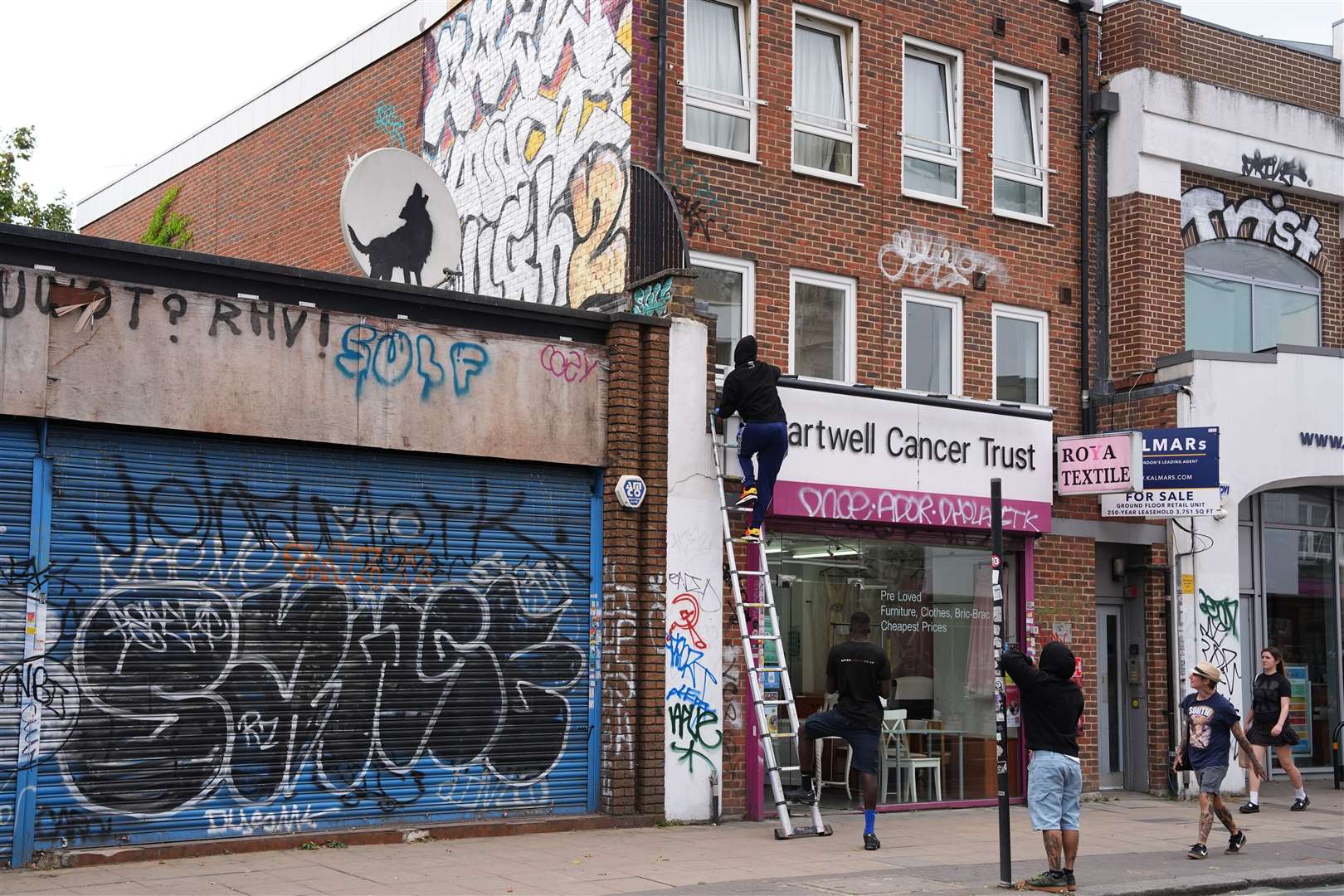 A man used a ladder to reach the artwork which was on a shop roof in Peckham, south-east London (Jordan Pettitt/PA)