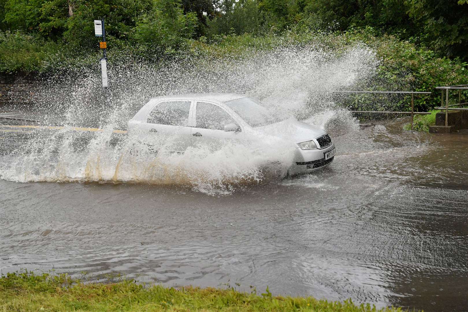 Cars drive through water after a river burst its banks in Bristol during flooding last summer (Ben Birchall/PA)