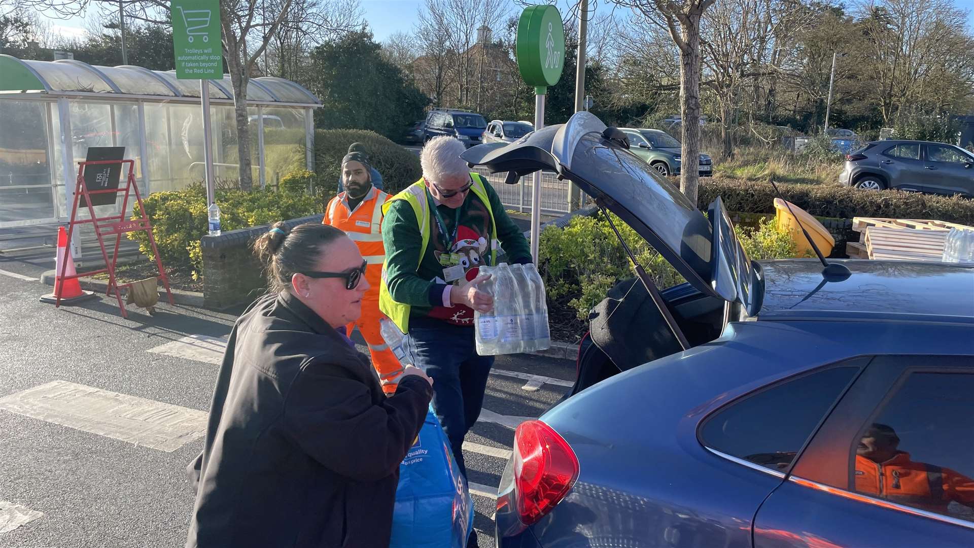 A helper loads a car at a bottle station at Asda, Totton (Ben Mitchell/PA)