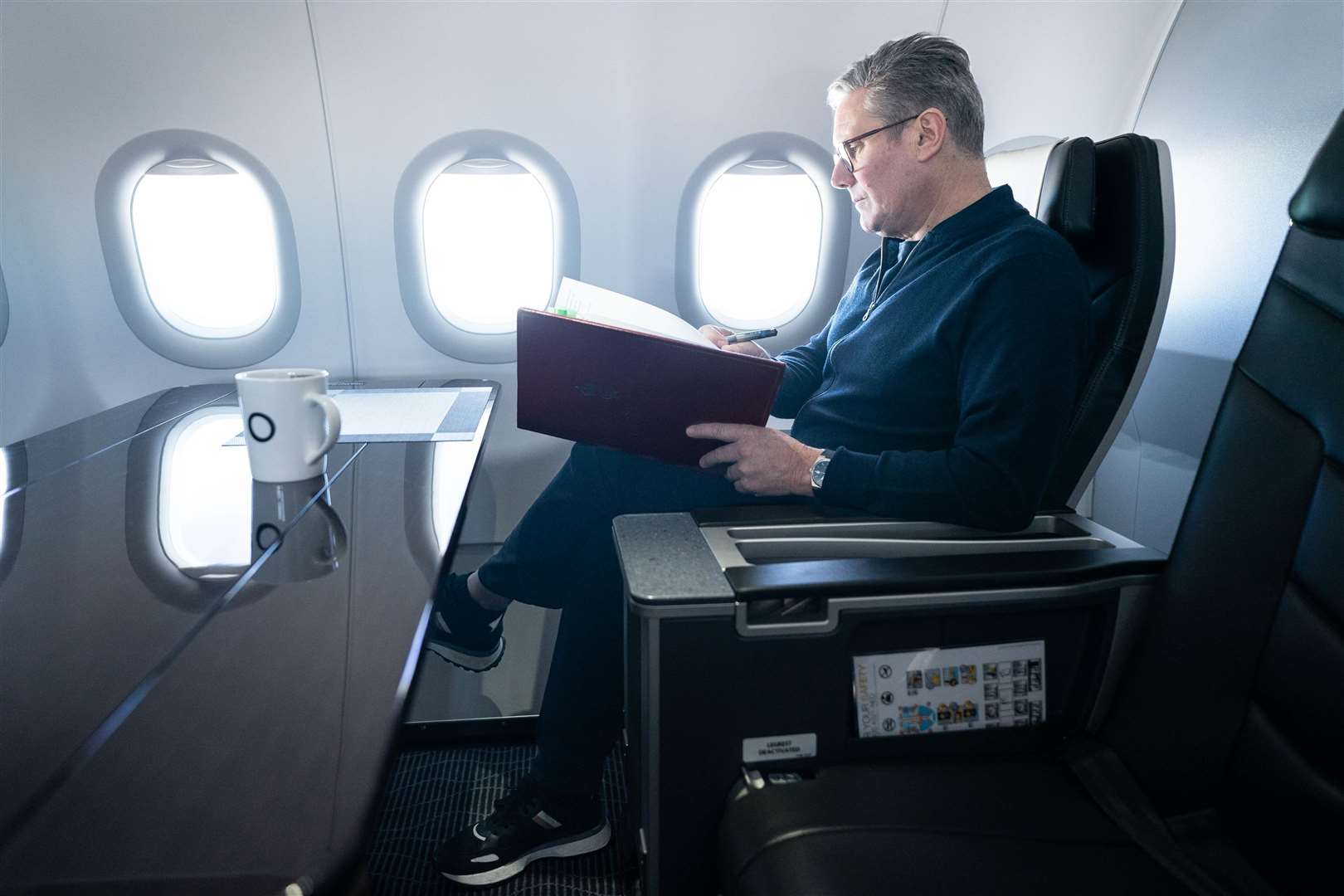 Prime Minister Sir Keir Starmer works on board a Government plane as he travels to Rio de Janeiro, Brazil to attend the G20 summit (Stefan Rousseau/PA)