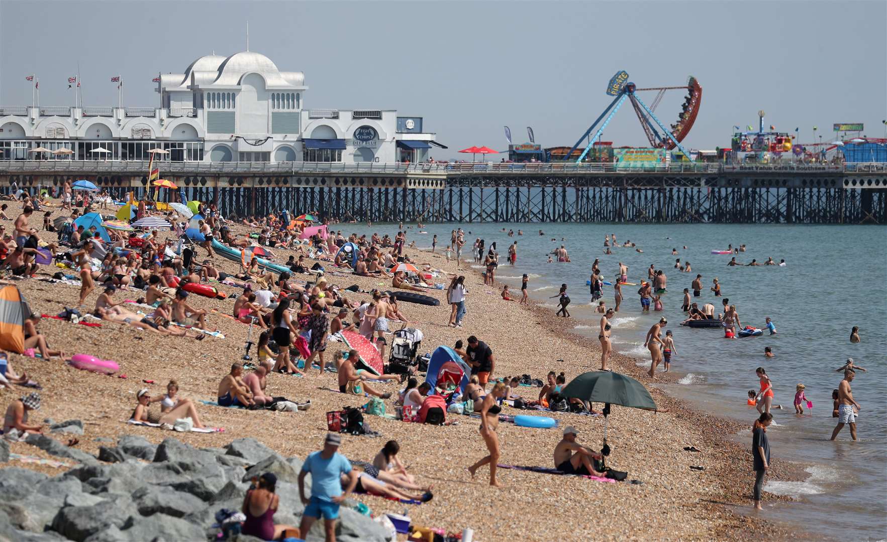 People enjoy the hot weather on Southsea beach in Hampshire in August (Andrew Matthews/PA)