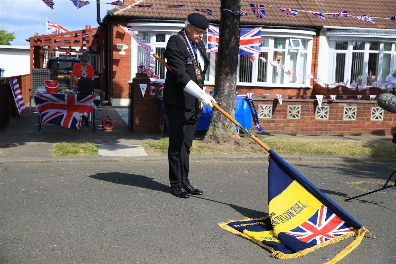 Eric Howden lowers his standard in respect in Redcar (Owen Humphreys/PA)