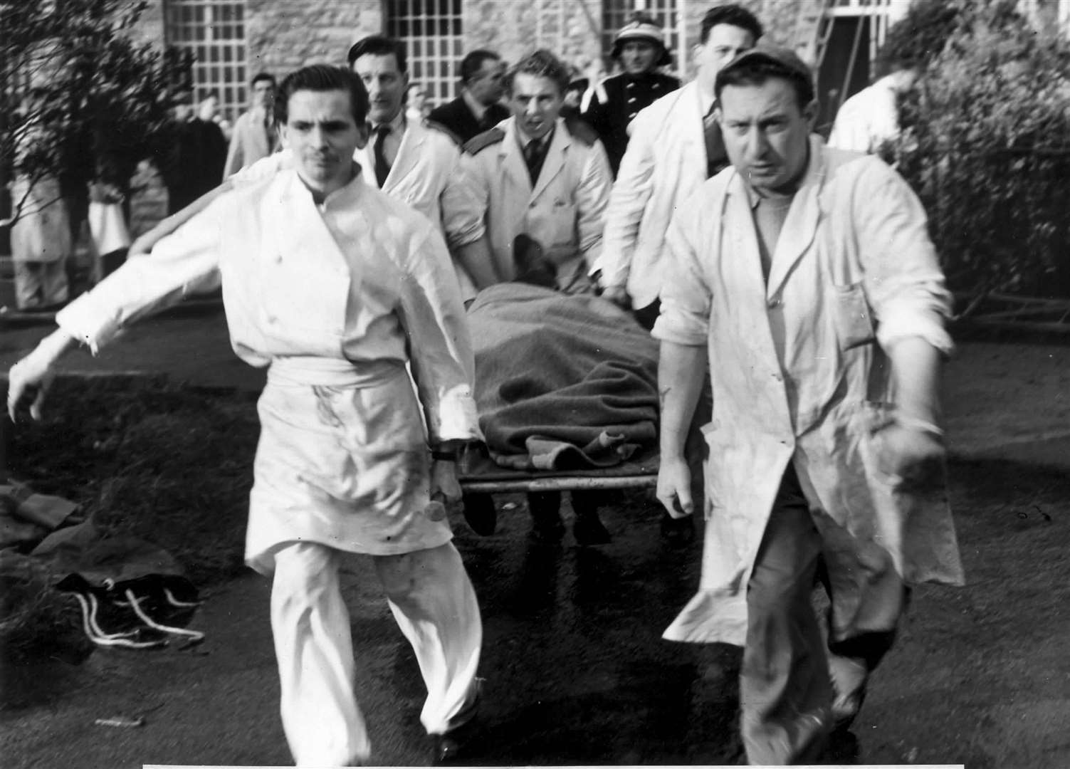Hospital staff bring a casualty from the building during the fire at Oakwood Hospital, Maidstone, in November 1957