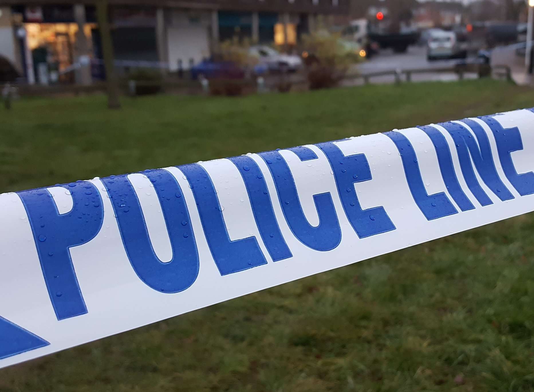 Police taped off a grassy area at the rear of the Brookfield Road shopping precinct