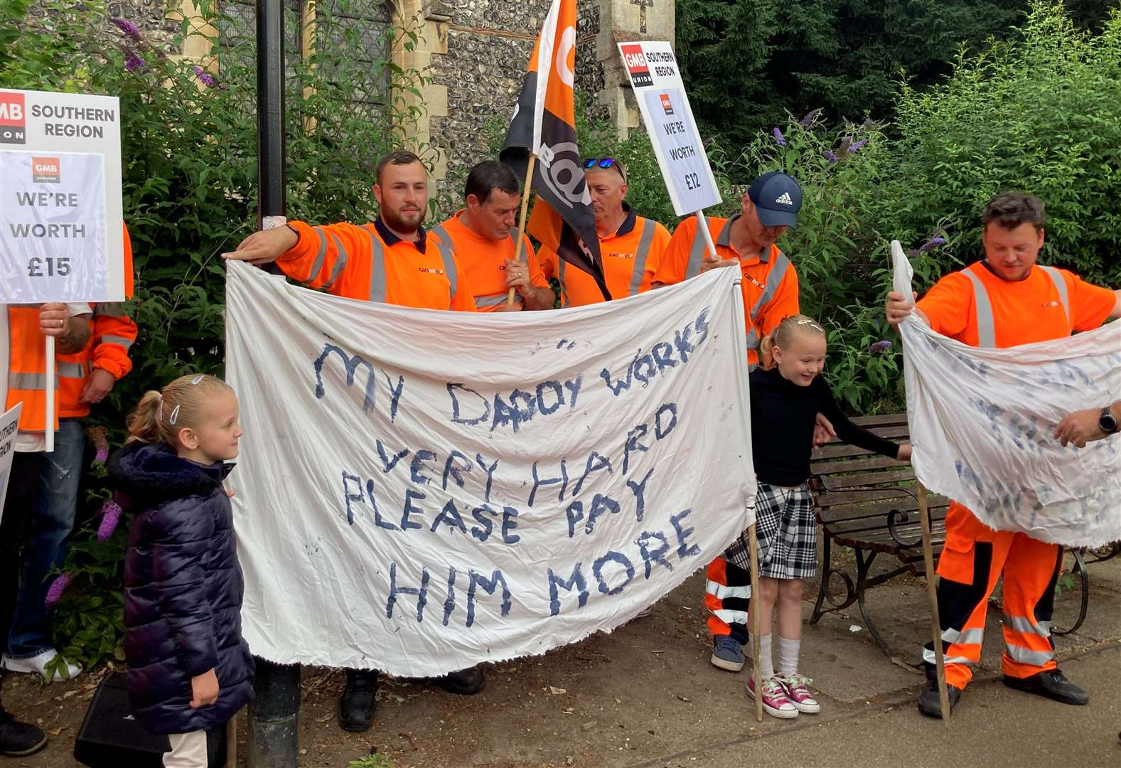 Striking refuse workers hold a banner and placards outside Canterbury Guildhall