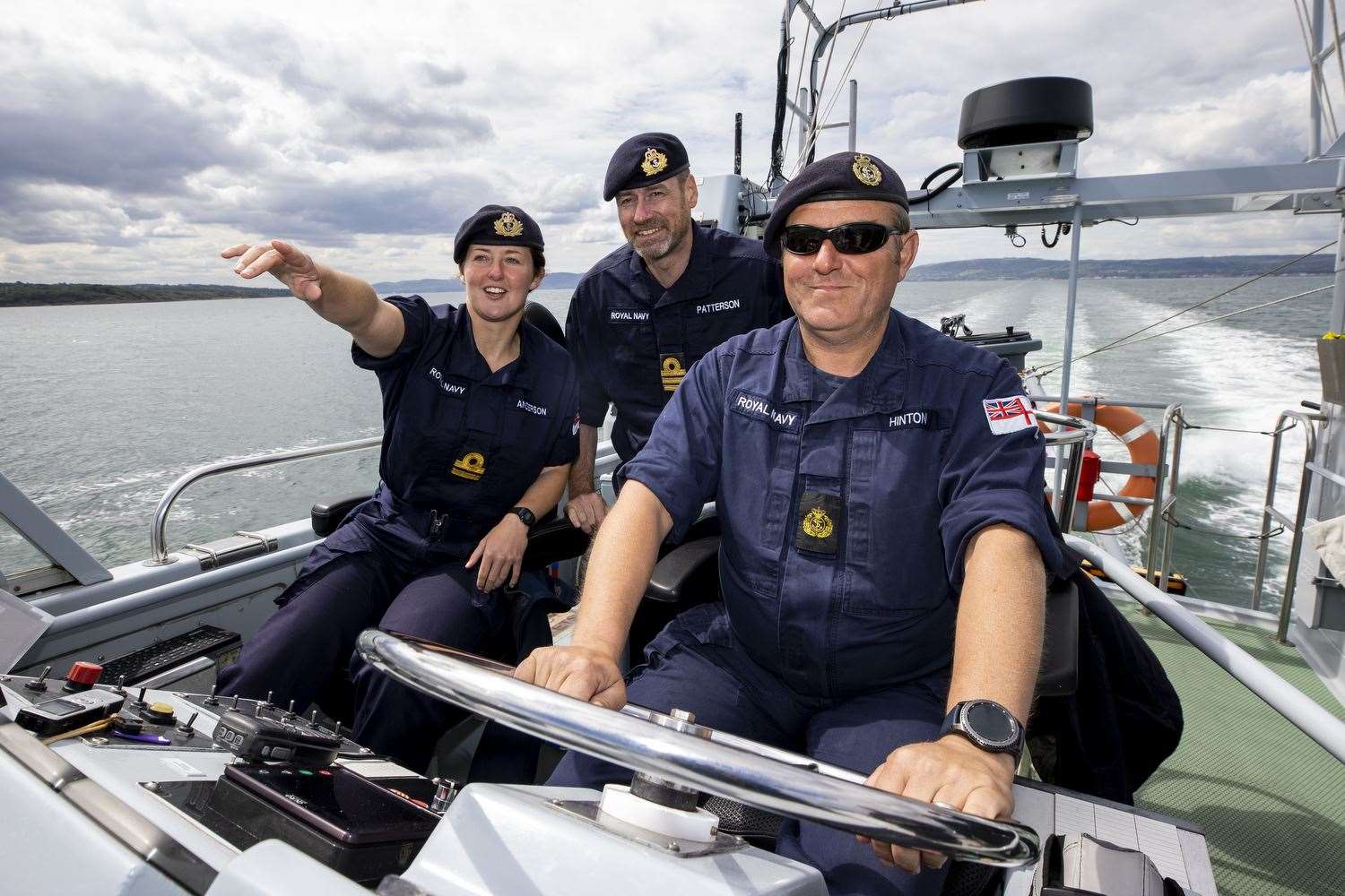 L-R Commanding Officer Lt Rebecca Anderson Royal Navy abroad HMS Biter with Senior Naval Officer Northern Ireland, Commander John Patterson, and CPO (ETME) Graeme Hinton at the helm during Ship’s in Company Close-in Manoeuvring along the north Antrim coastline. (Liam McBurney/PA)