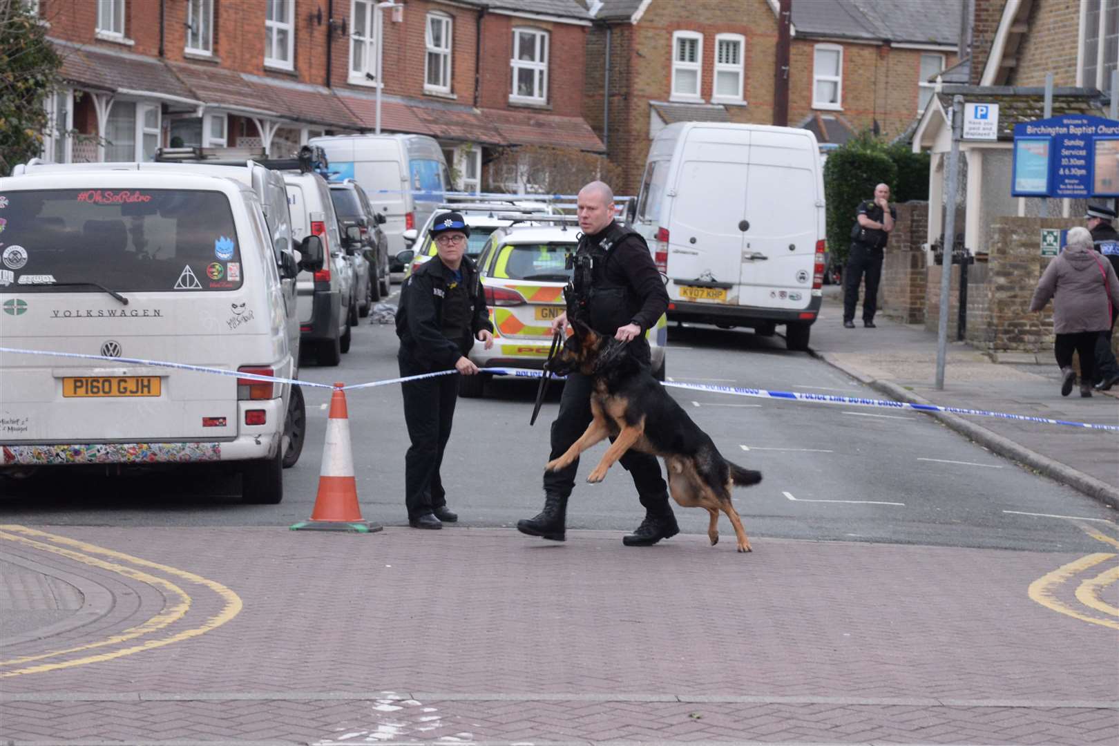 A police dog handler with officers investigating after the stabbing