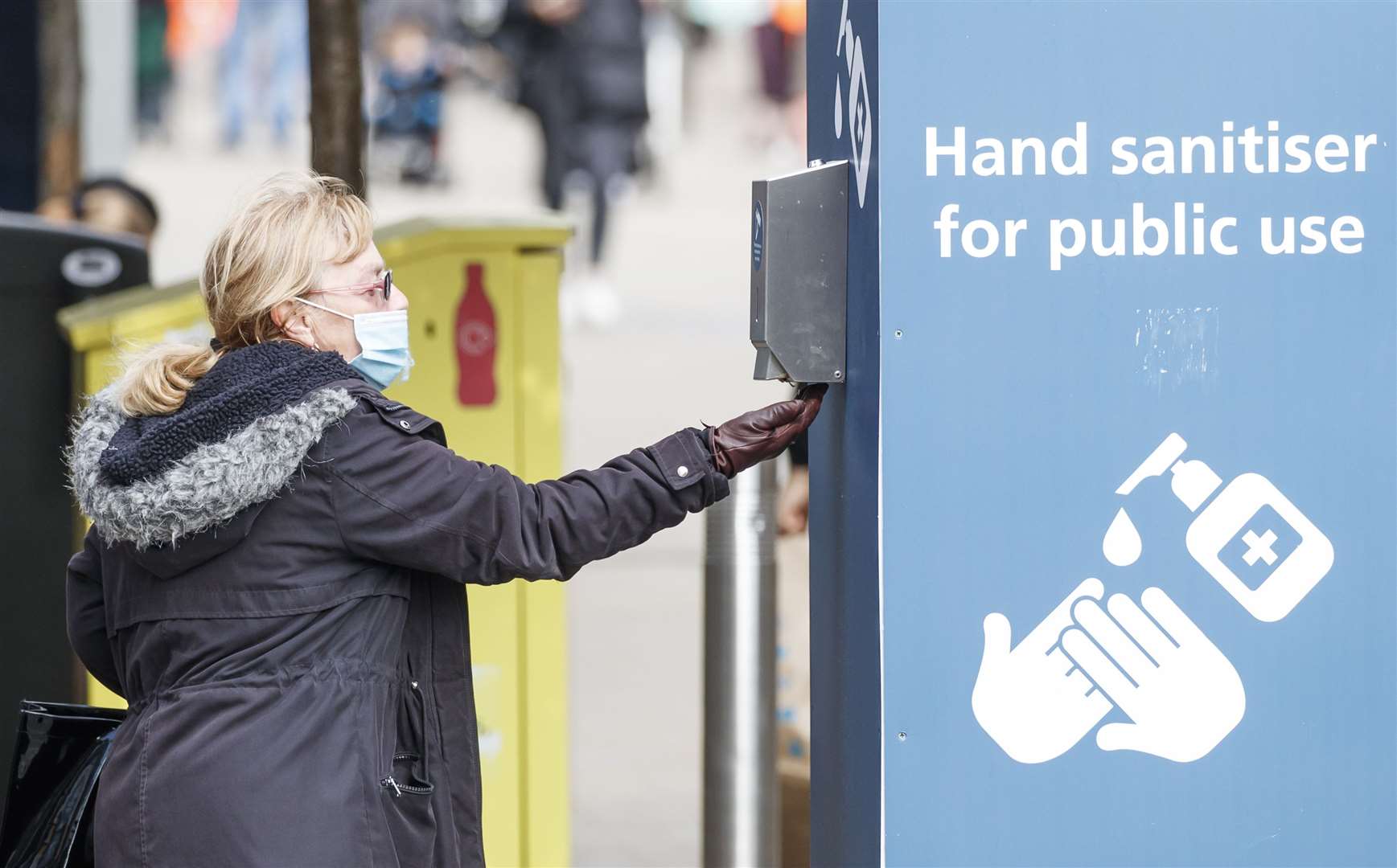 A woman uses a public hand sanitiser in Leeds (Danny Lawson/PA)