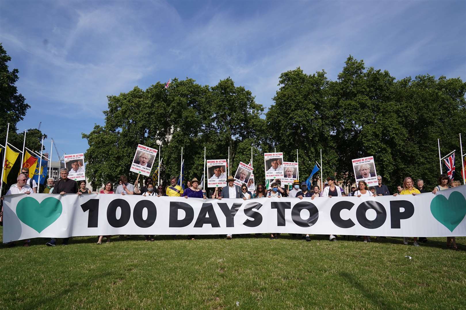 Campaigners hold a banner during a demonstration in London’s Parliament Square to mark 100 days to go until the Cop26 climate summit in Glasgow (Stefan Rousseau/PA)