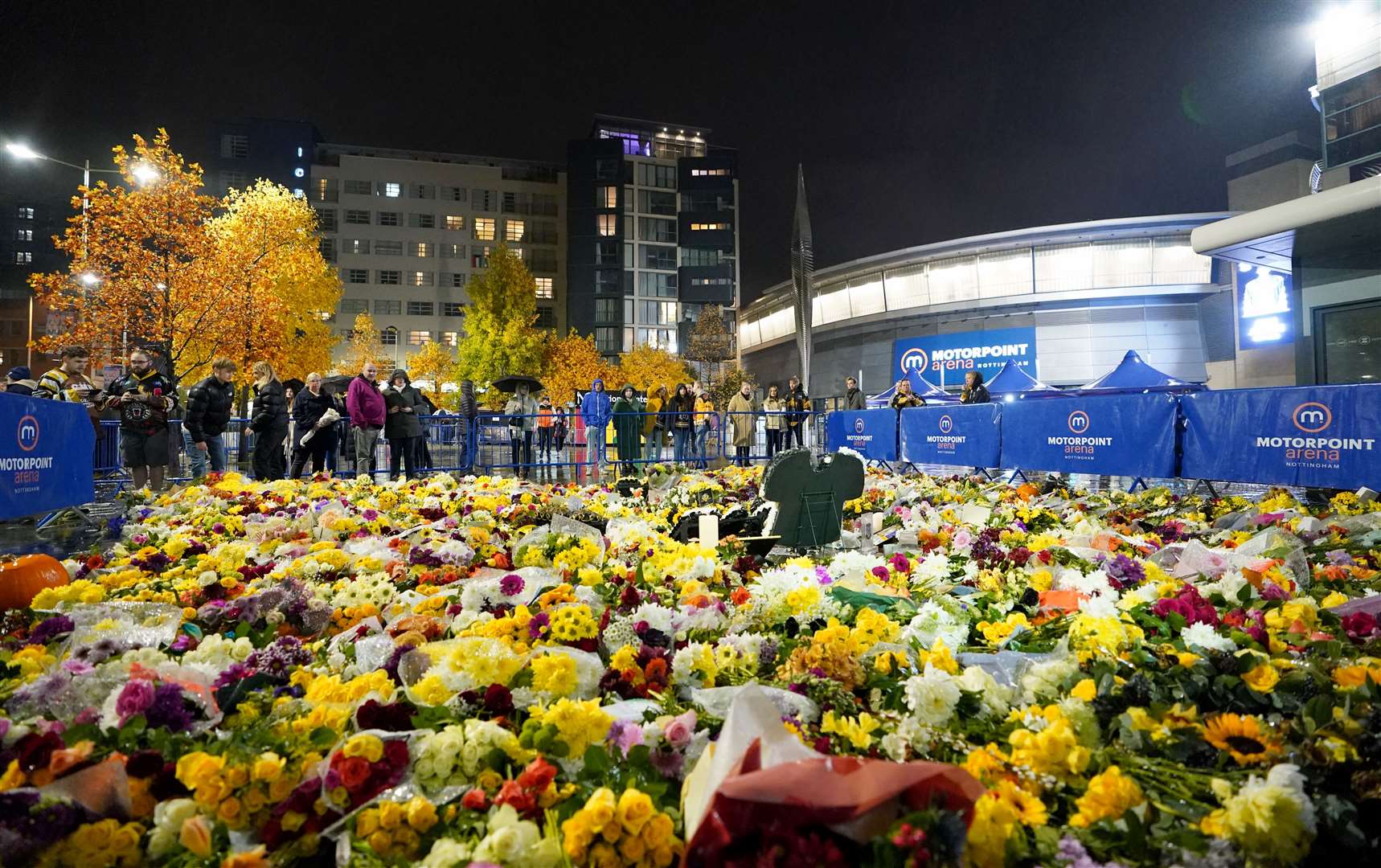 Fans look at floral tributes to Adam Johnson outside the Motorpoint Arena in Nottingham (Zac Goodwin/PA)