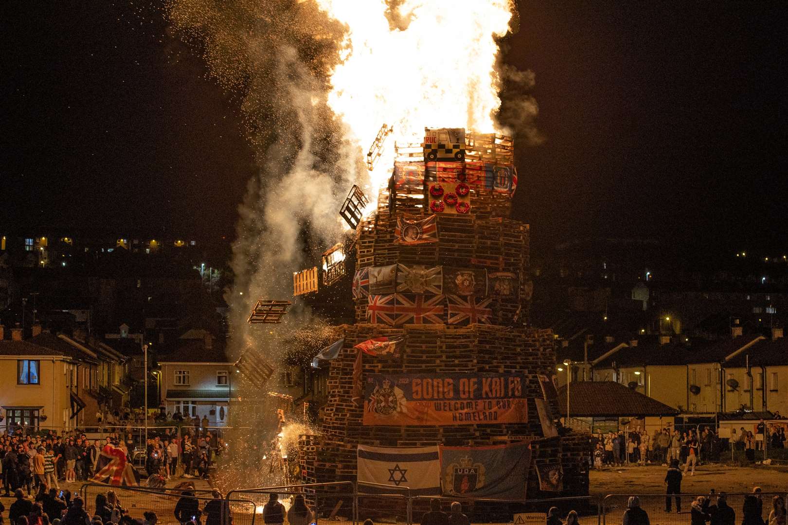 People gather at the burning of a bonfire to mark the Catholic Feast of the Assumption in the Bogside area of Londonderry (Liam McBurney/PA)