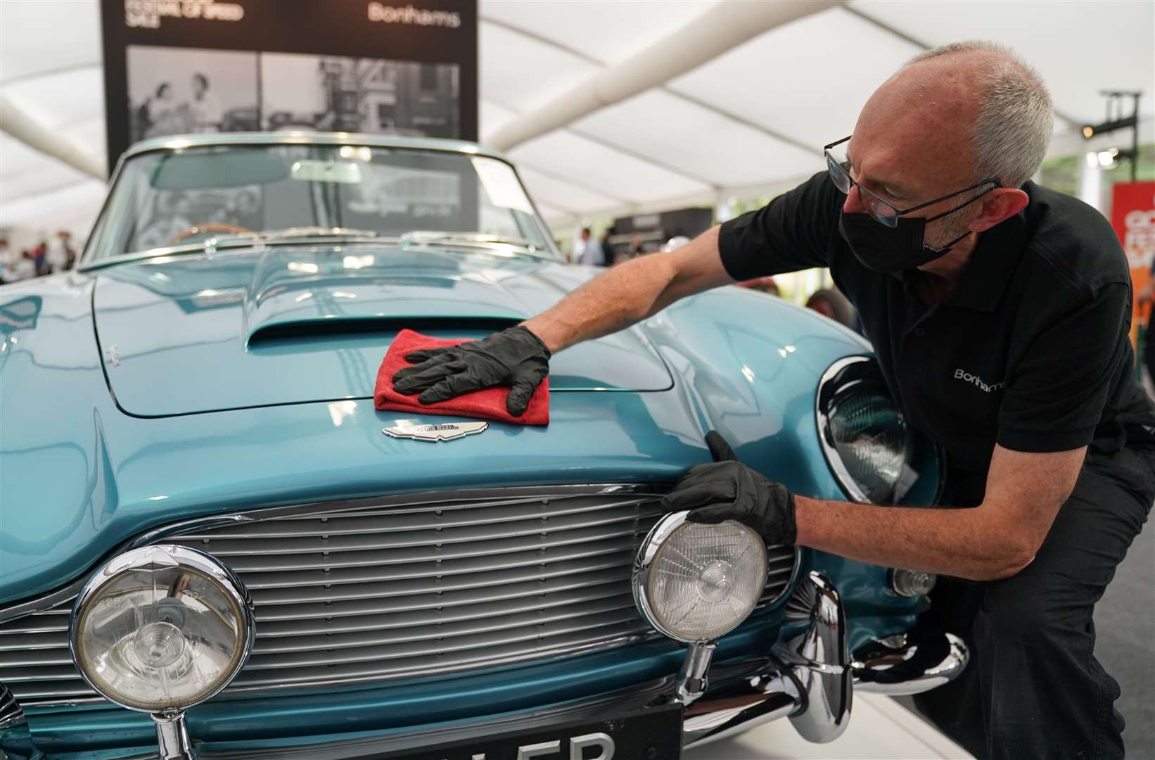 Chris Bailey, of Bonhams, cleans the 1964 Aston Martin DB5 convertible (Andrew Matthews/PA)