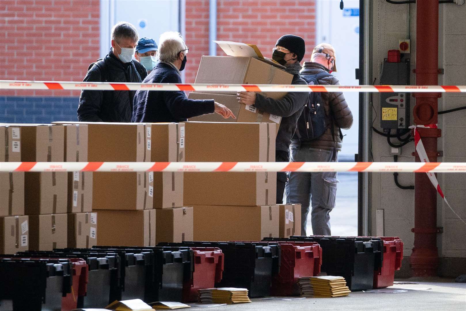 Boxes of coronavirus testing kits are prepared at Woking Fire Station, prior to the start of door-to-door coronavirus testing in parts of England to find cases of the South Africa variant (Dominic Lipinski/PA)