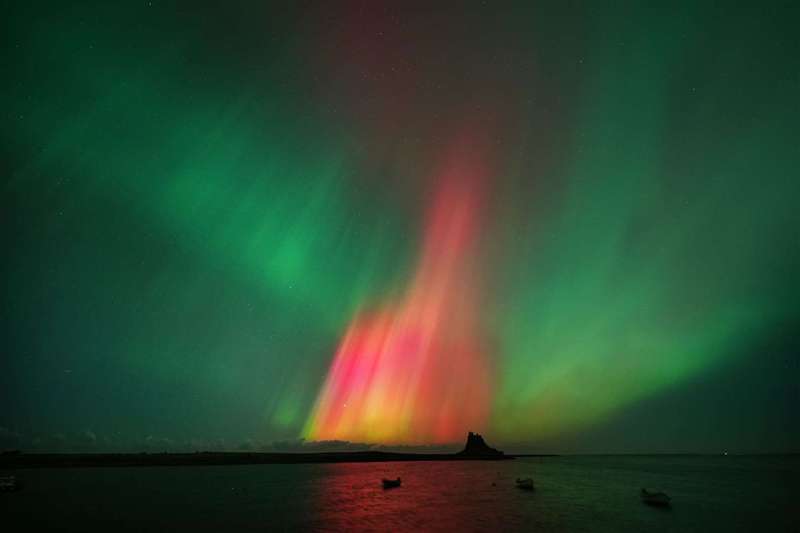 A lovely match of foreground and background as the lights appear over Lindisfarne Castle on Holy Island in Northumberland (Owen Humphreys/PA)