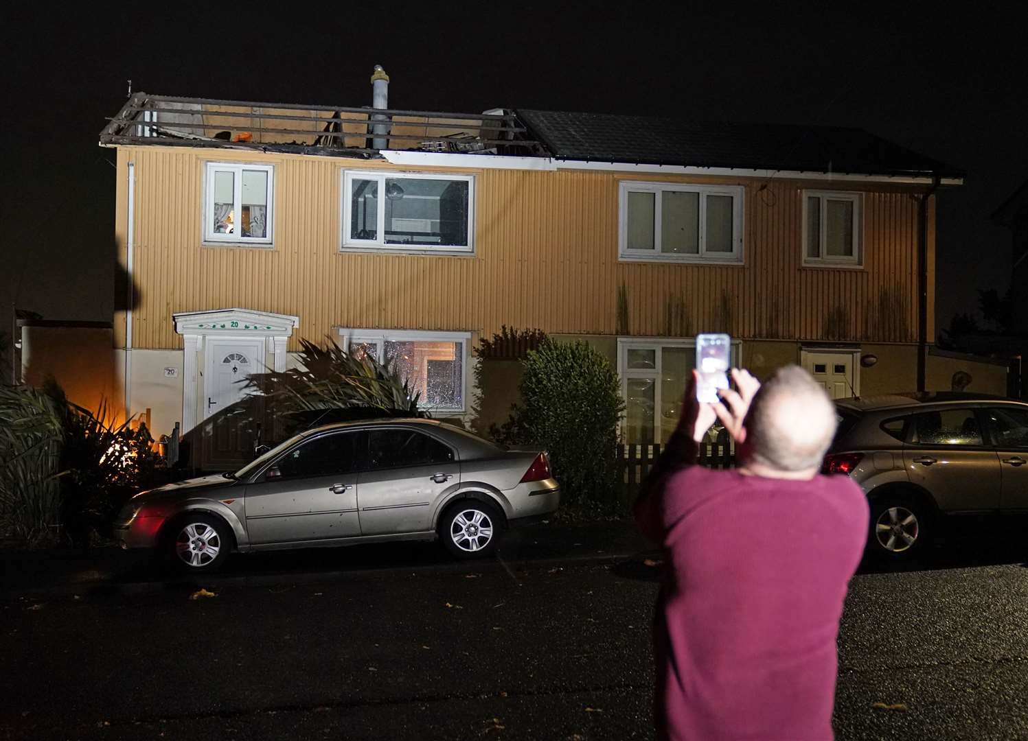 A homeowner, who lost the roof of his house in strong winds, takes a picture in Blackhall, County Durham (Owen Humphreys/PA)