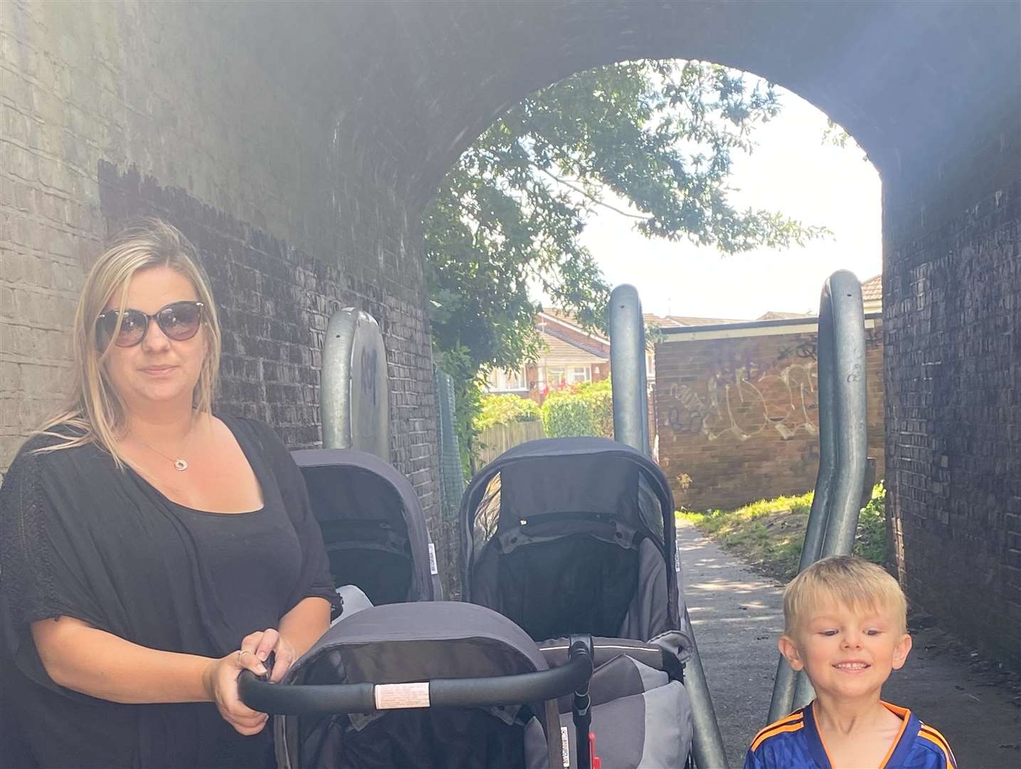 Natalie Jackson, her son, Finley, 5, and her triplet buggy struggling to get through the anti-bike barriers between Archers Park and Grove Park, Sittingbourne