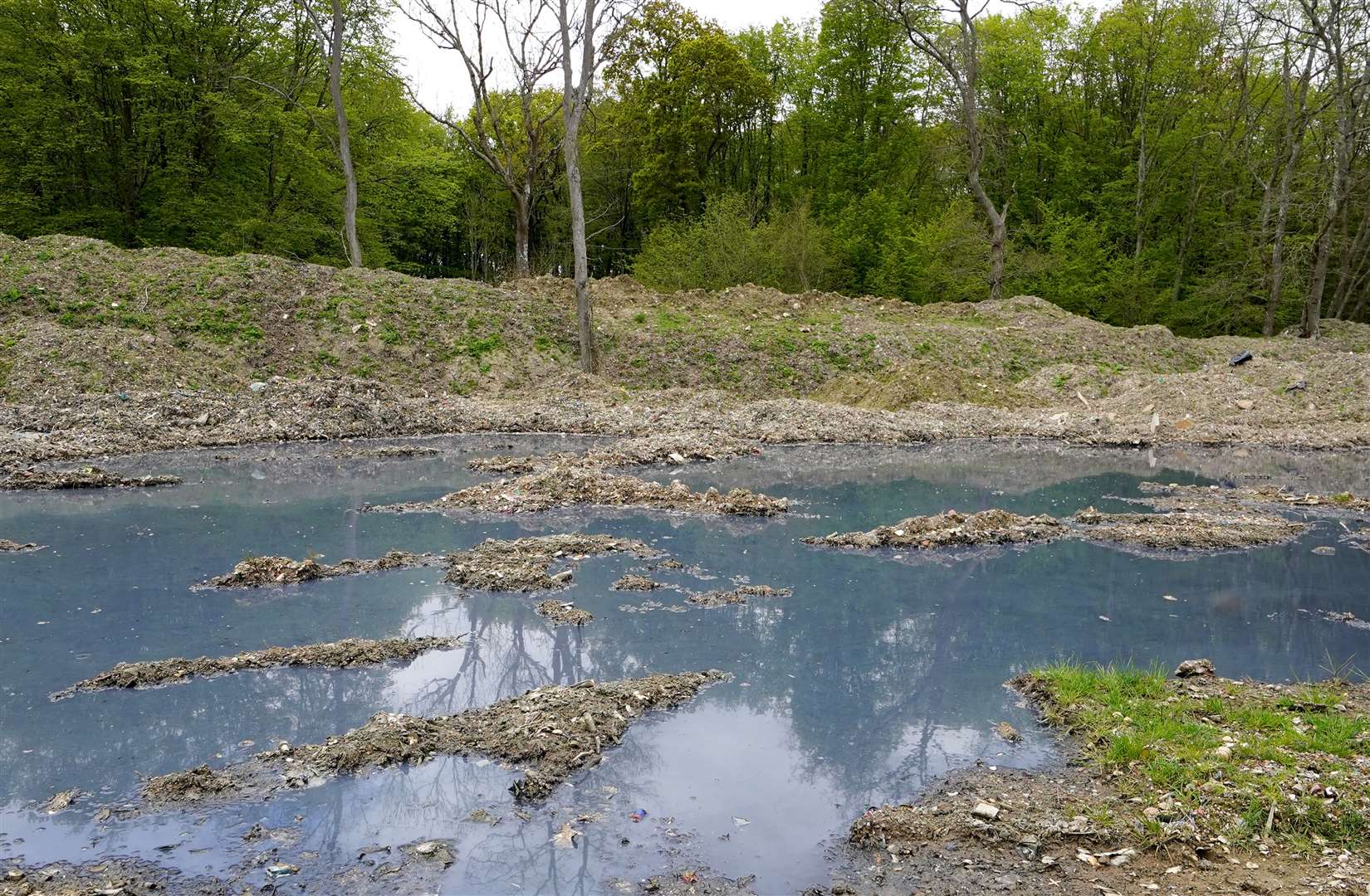 Blue water at Hoad’s Wood where thousands of tonnes of illegal waste has been dumped (Gareth Fuller/PA)