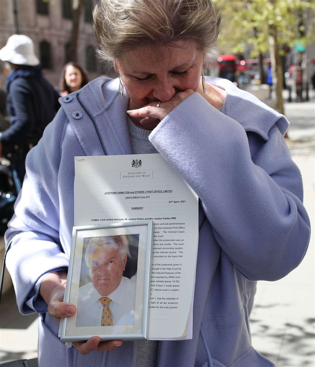 Karen Wilson, widow of postmaster Julian Wilson who died in 2016, holds a photograph of her husband outside the Royal Courts of Justice in April after his conviction was overturned (Yui Mok/PA)