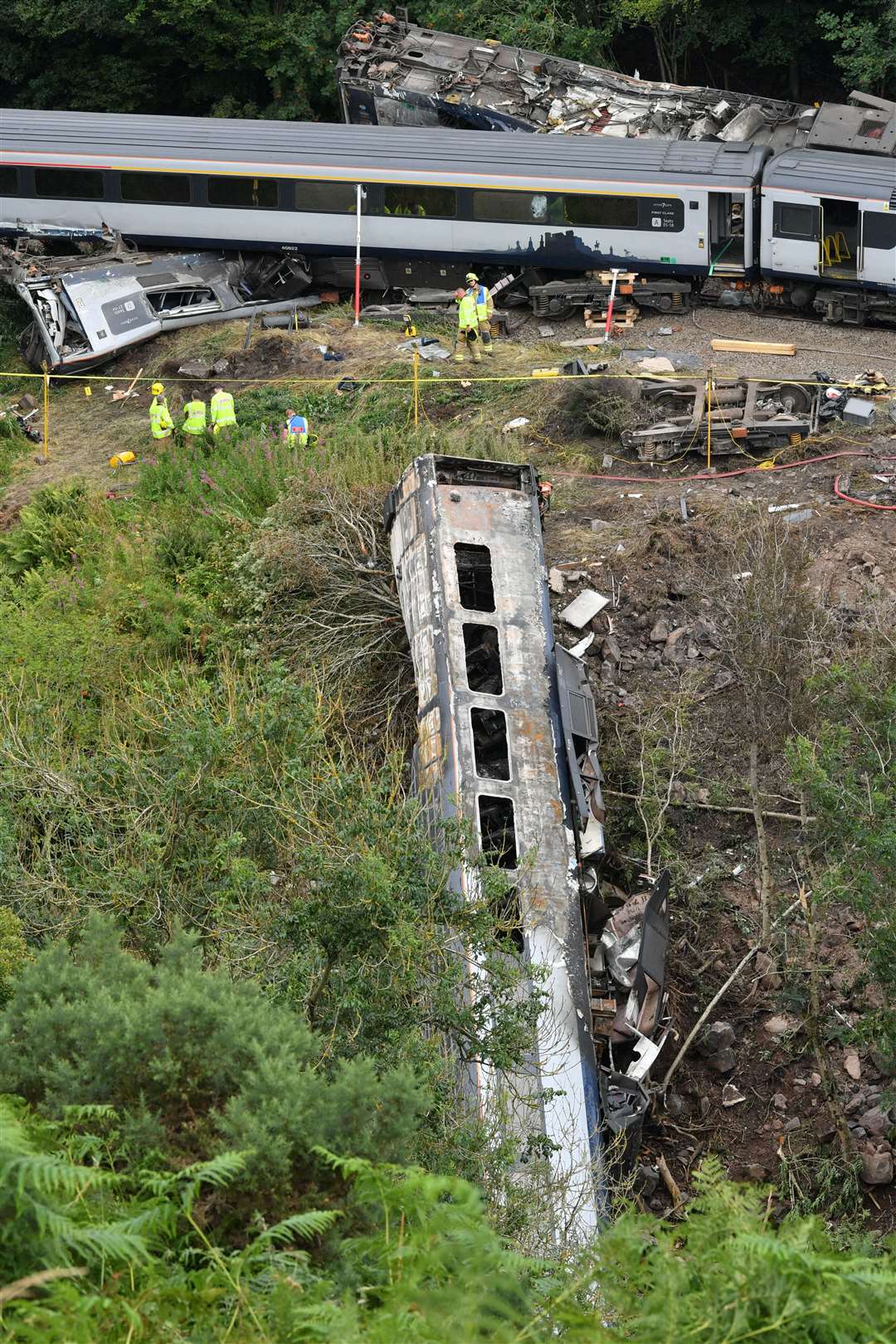 Two carriages fell down the embankment and went up in flames (Ben Birchall/PA)