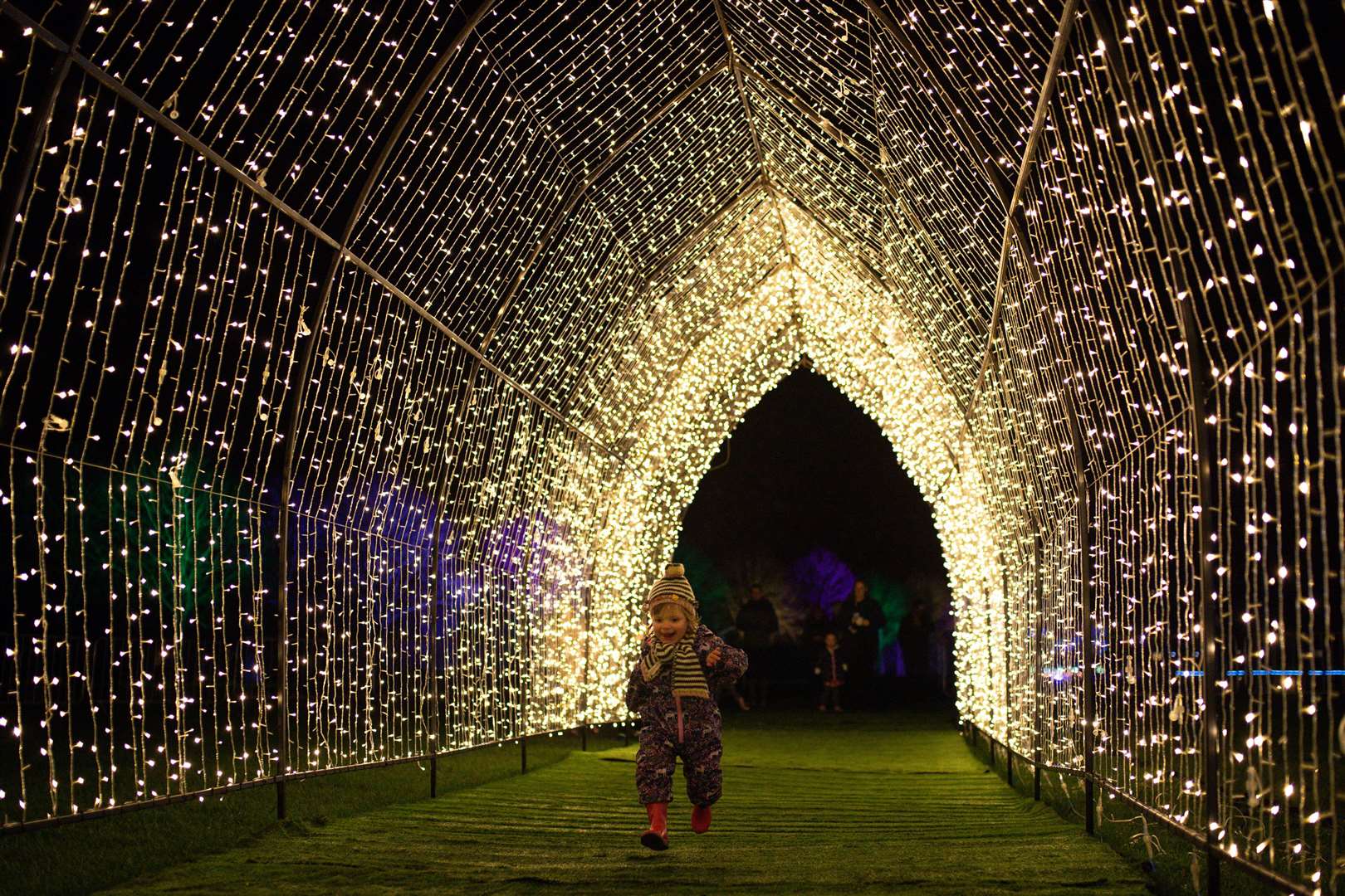 Toddler Piper Smith makes her way through one of the illuminated tunnels (Jacob King/PA)