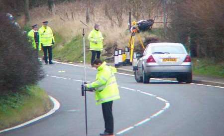 Police at the scene with the motorbike on the embankment