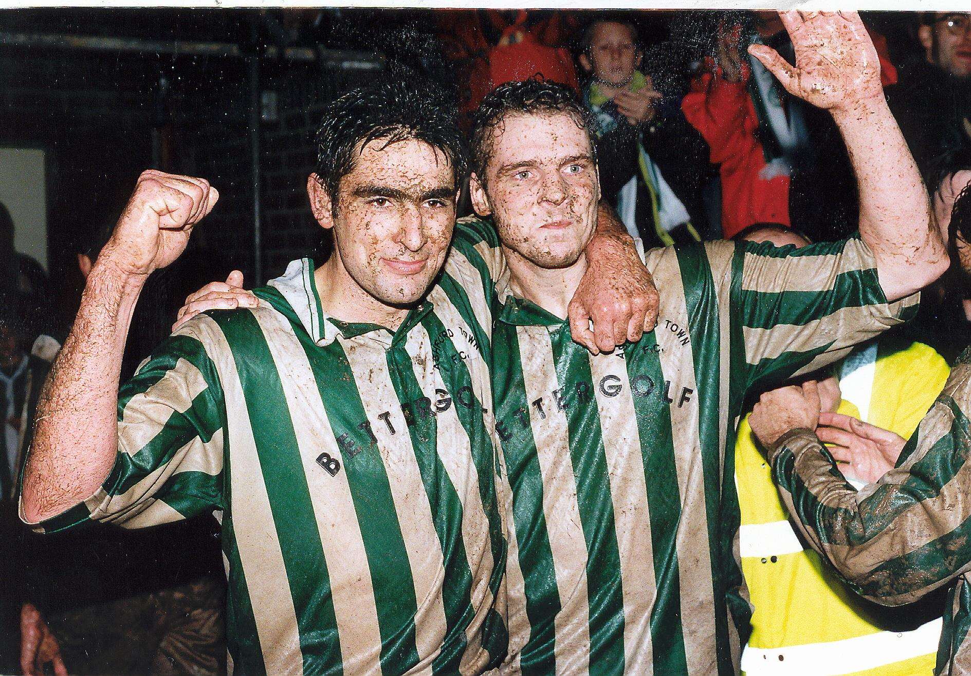 Dave Arter and Nicky Dent celebrate in the mud after Ashford Town's FA Cup home draw with Fulham