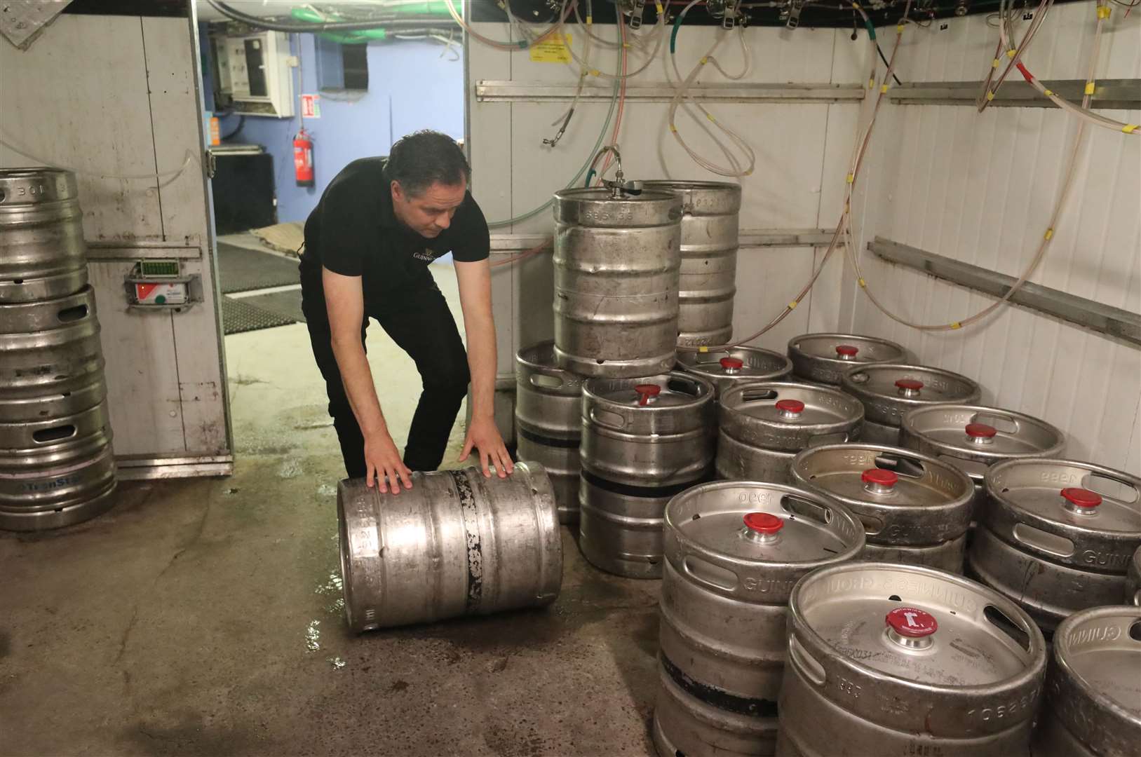 Mr Brzyk stacks fresh kegs of Guinness at Paddy Cullen’s pub (Niall Carson/PA)