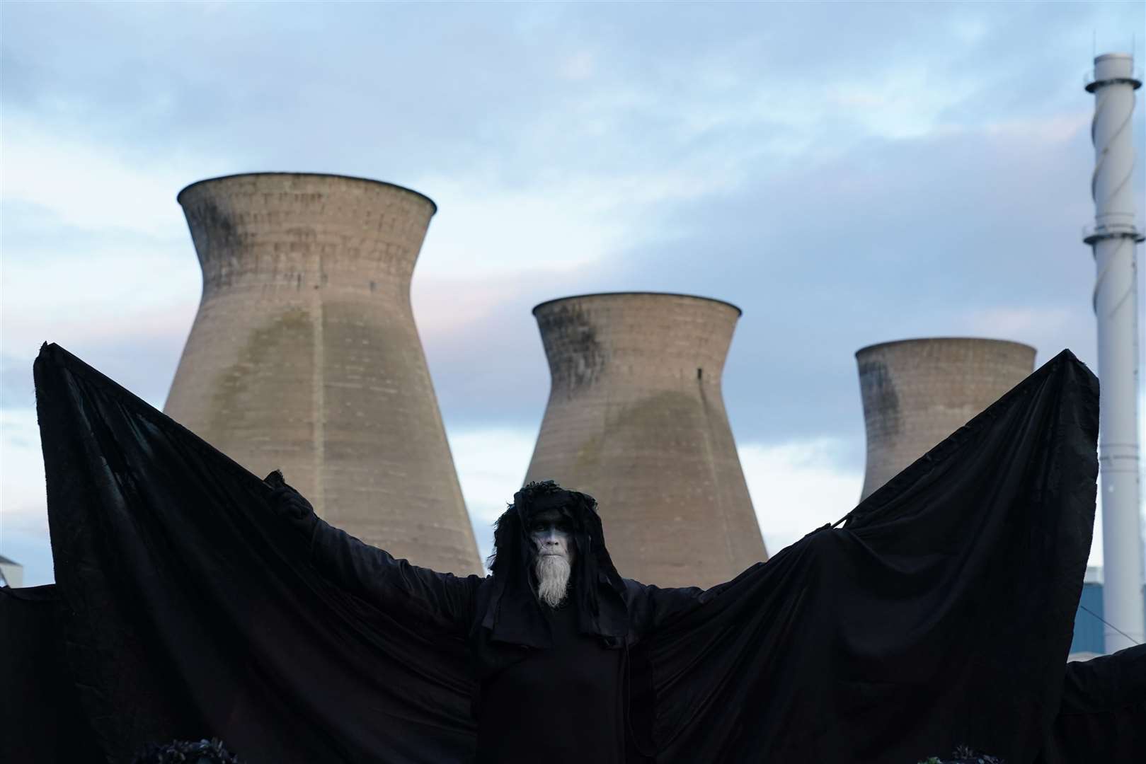 A climate activist from Ocean Rebellion, representing an ‘oil slick’, protests outside Grangemouth oil refinery in Falkirk (Andrew Milligan/PA)