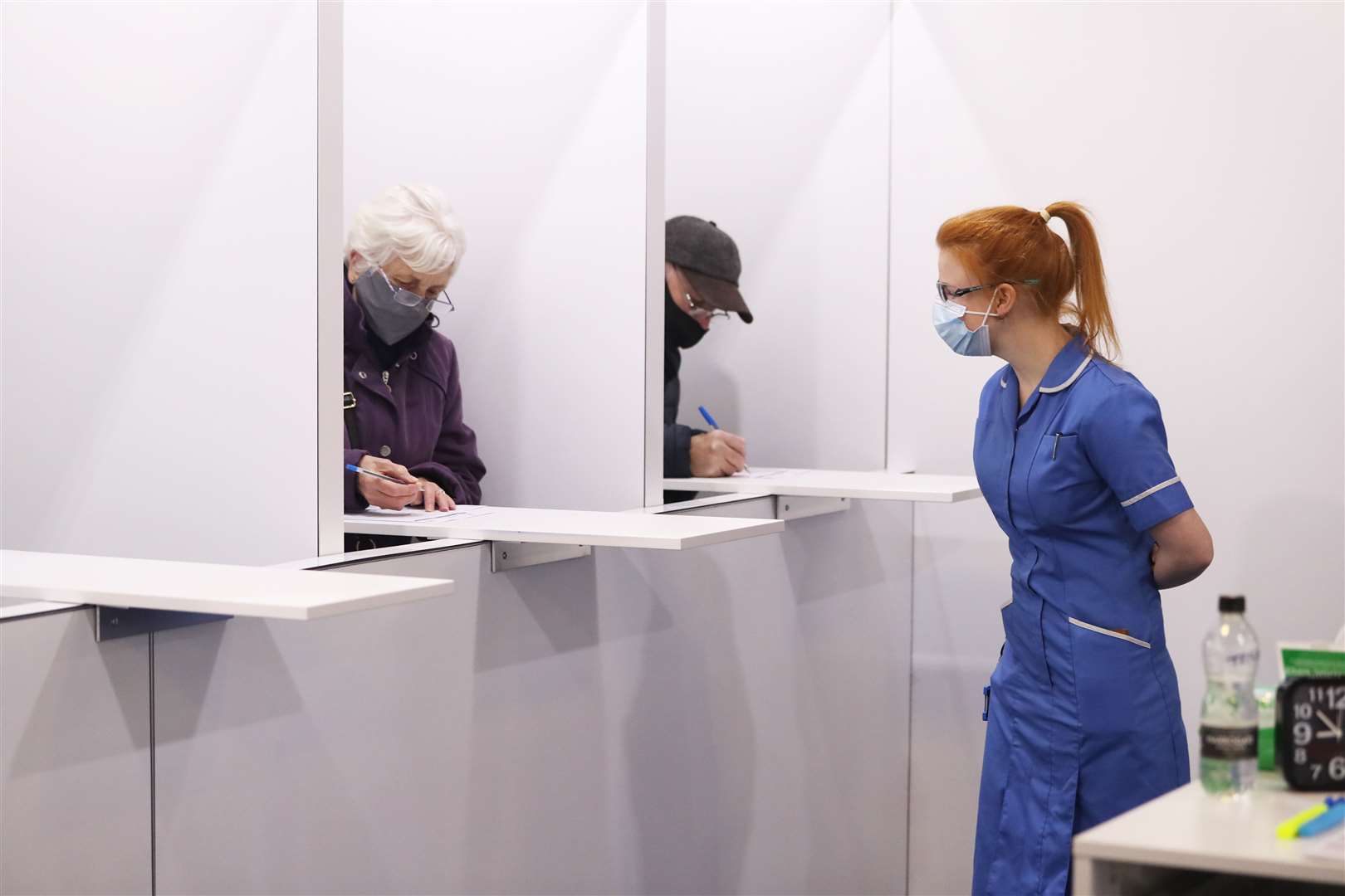 Members of the public fill out paperwork before being given the Oxford/AstraZeneca coronavirus vaccine at the Elland Road vaccination centre in Leeds (Danny Lawson/PA)