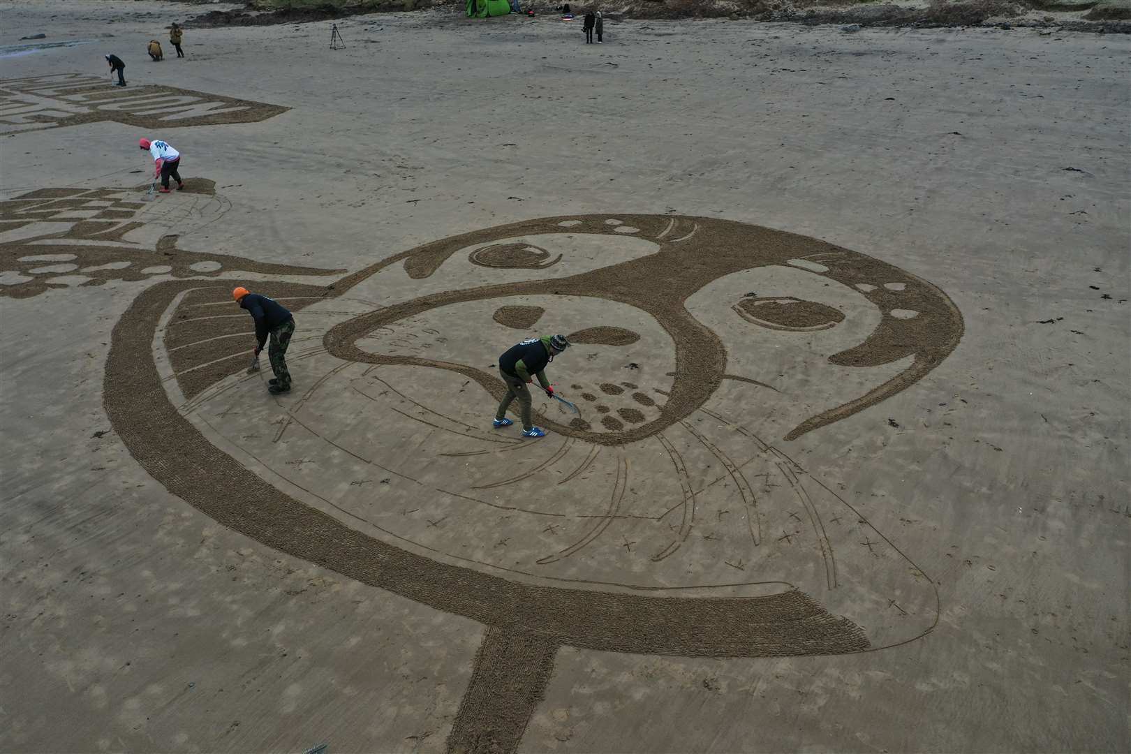 The sand drawing is being used to launch what campaigners say will be the UK’s biggest beach clean (Richard McCarthy/PA)