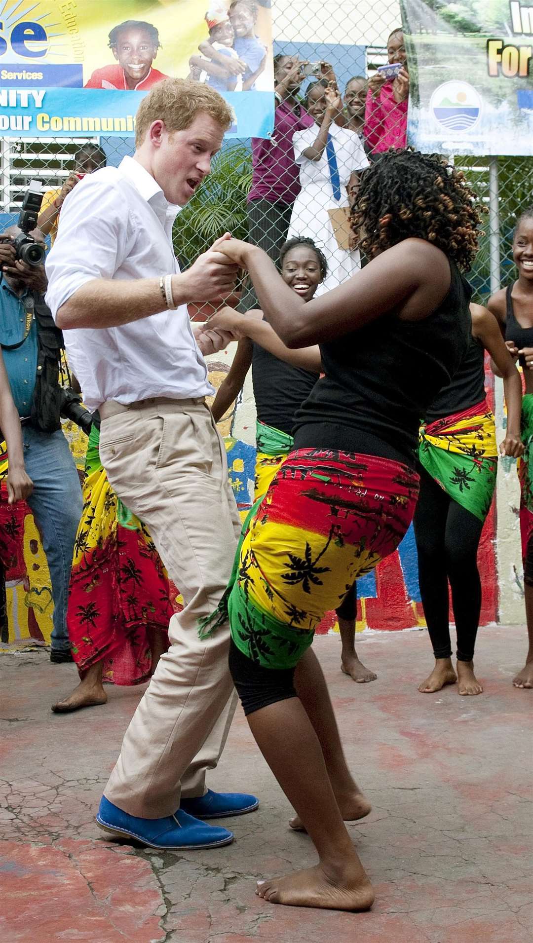 Harry dances with a woman during a visit to the Rise Life charity project, in Jamaica, as part of a Diamond Jubilee tour where he represented his grandmother (John Stillwell/PA)