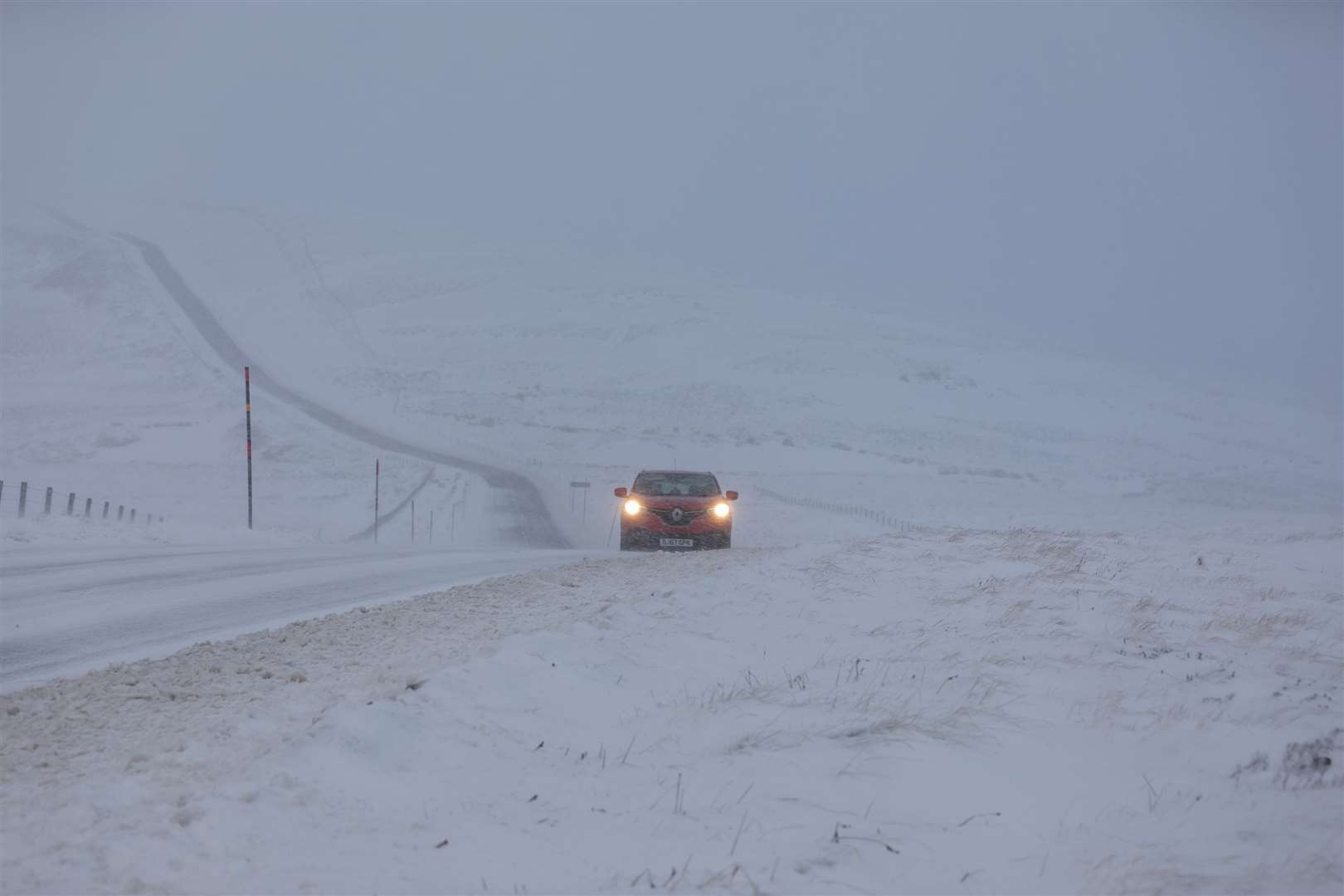 A car makes its way along the A939 after heavy snowfall in the Cairngorms, Scottish Highlands (Paul Campbell/PA)