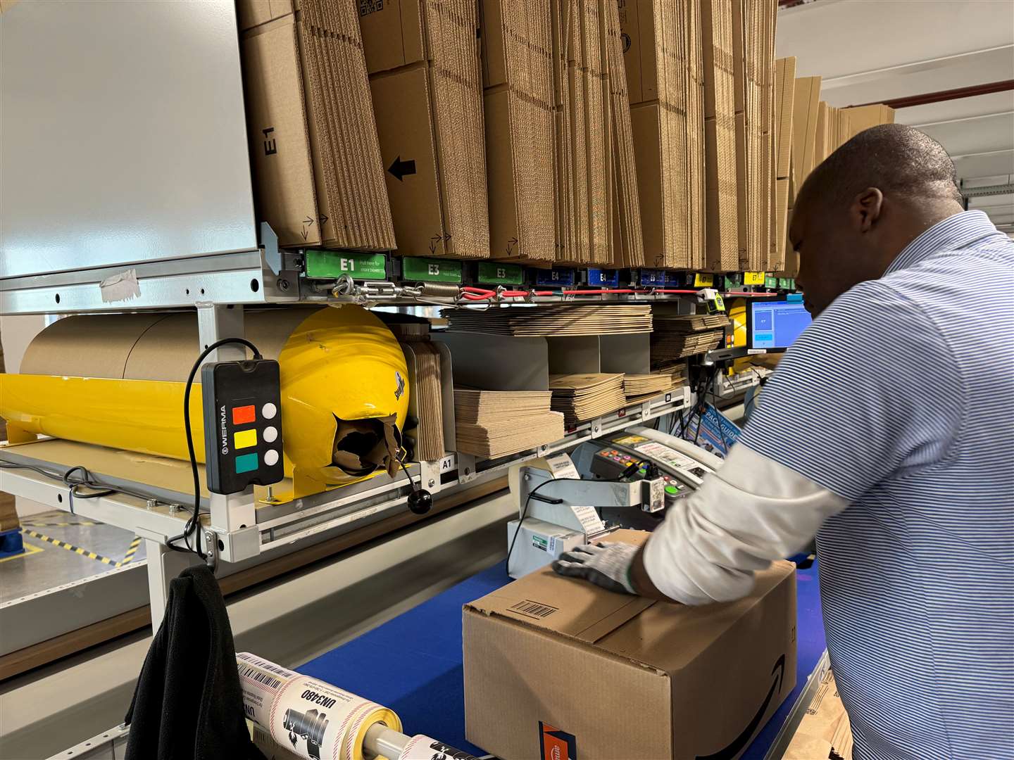 An Amazon employee puts together a package ready to be labelled and sent out from its Dartford warehouse