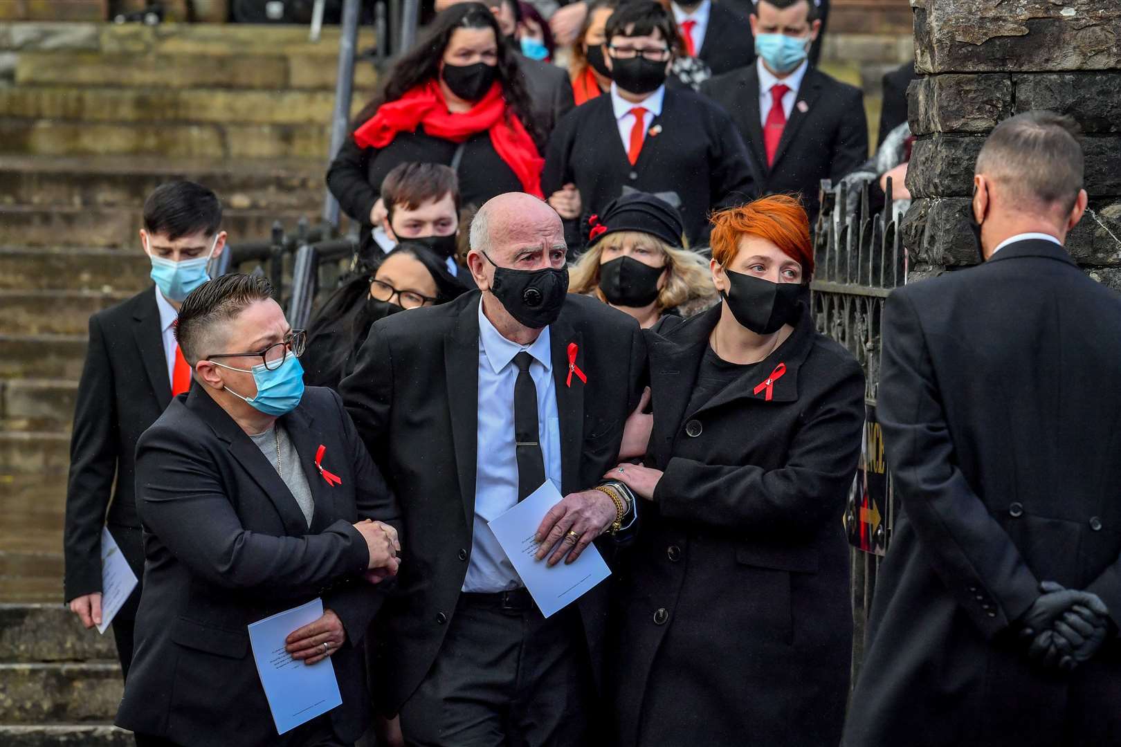 Husband and father David Lewis (centre) is helped out of church (Ben Birchall/PA)