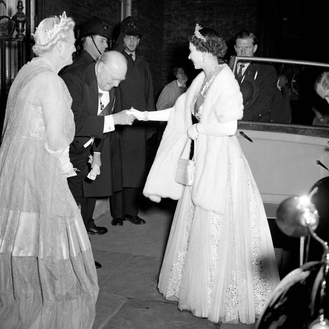 Sir Winston Churchill – the first prime minister of the Queen’s reign – bows to the monarch in 1955 (PA)