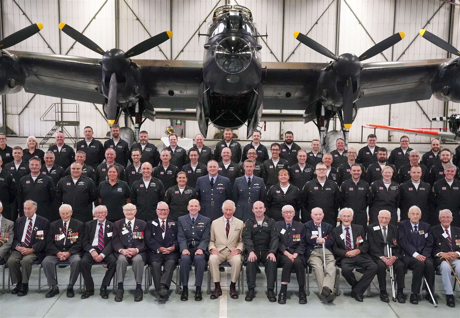 The King Charles poses for a photograph with staff and Second World War veterans, during a visit to the Battle of Britain Memorial Flight (BBMF) in Coningsby, Lincolnshire (Arthur Edwards/The Sun/PA)