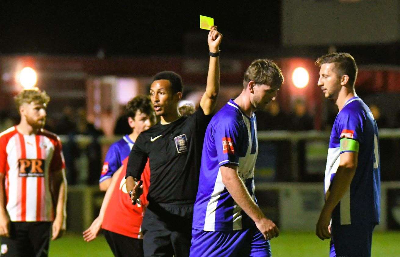 Referee Deryll David cautions Herne Bay's Tom Hanfrey at Holm Park. Picture: Marc Richards