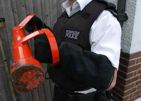 One of the police officers about to enter the property. Picture: BARRY GOODWIN