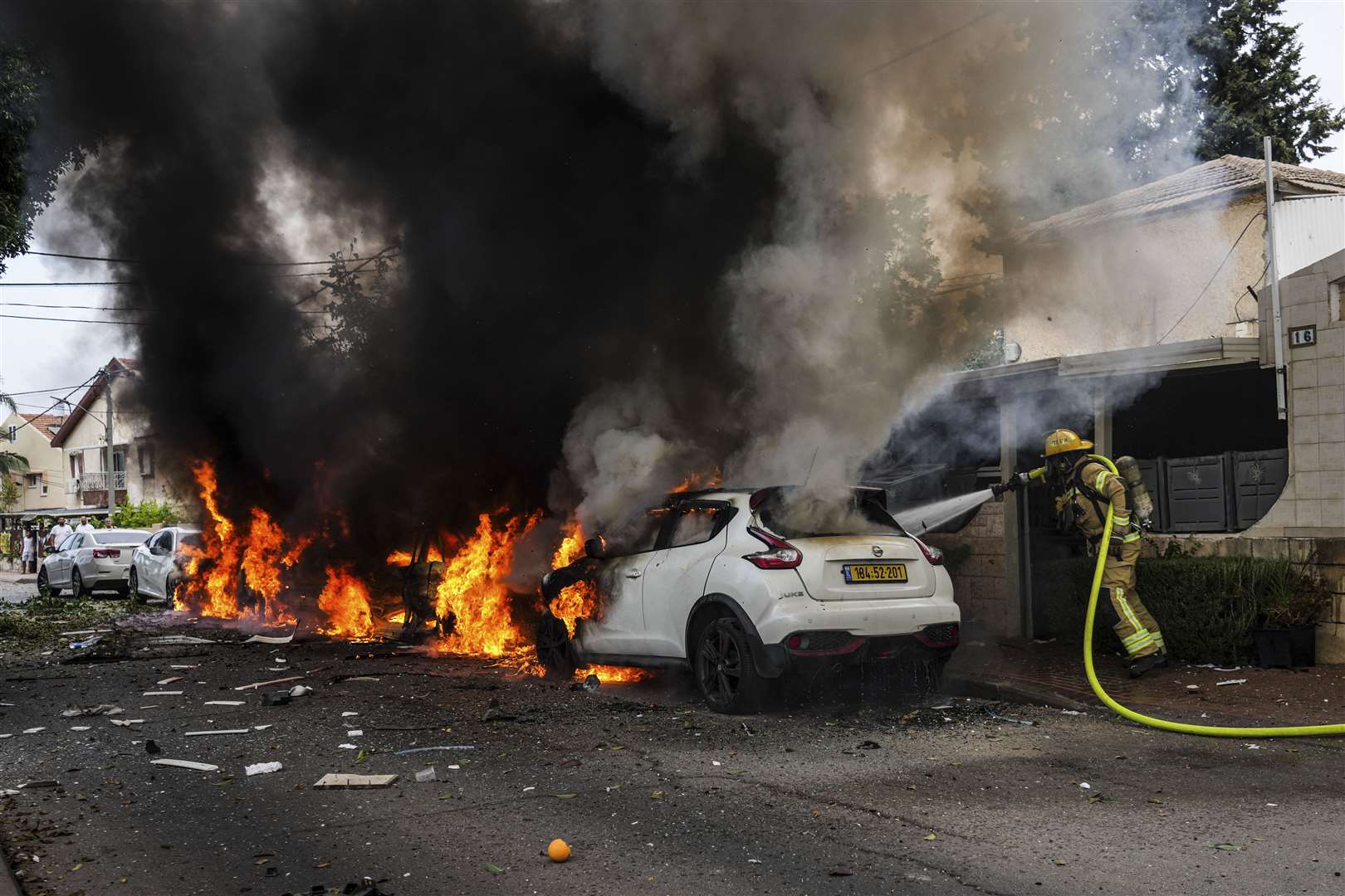 Israeli firefighters extinguish fire at a site struck by a rocket fired from the Gaza Strip in Ashkelon, southern Israel on Monday (Tsafrir Abayov/AP)